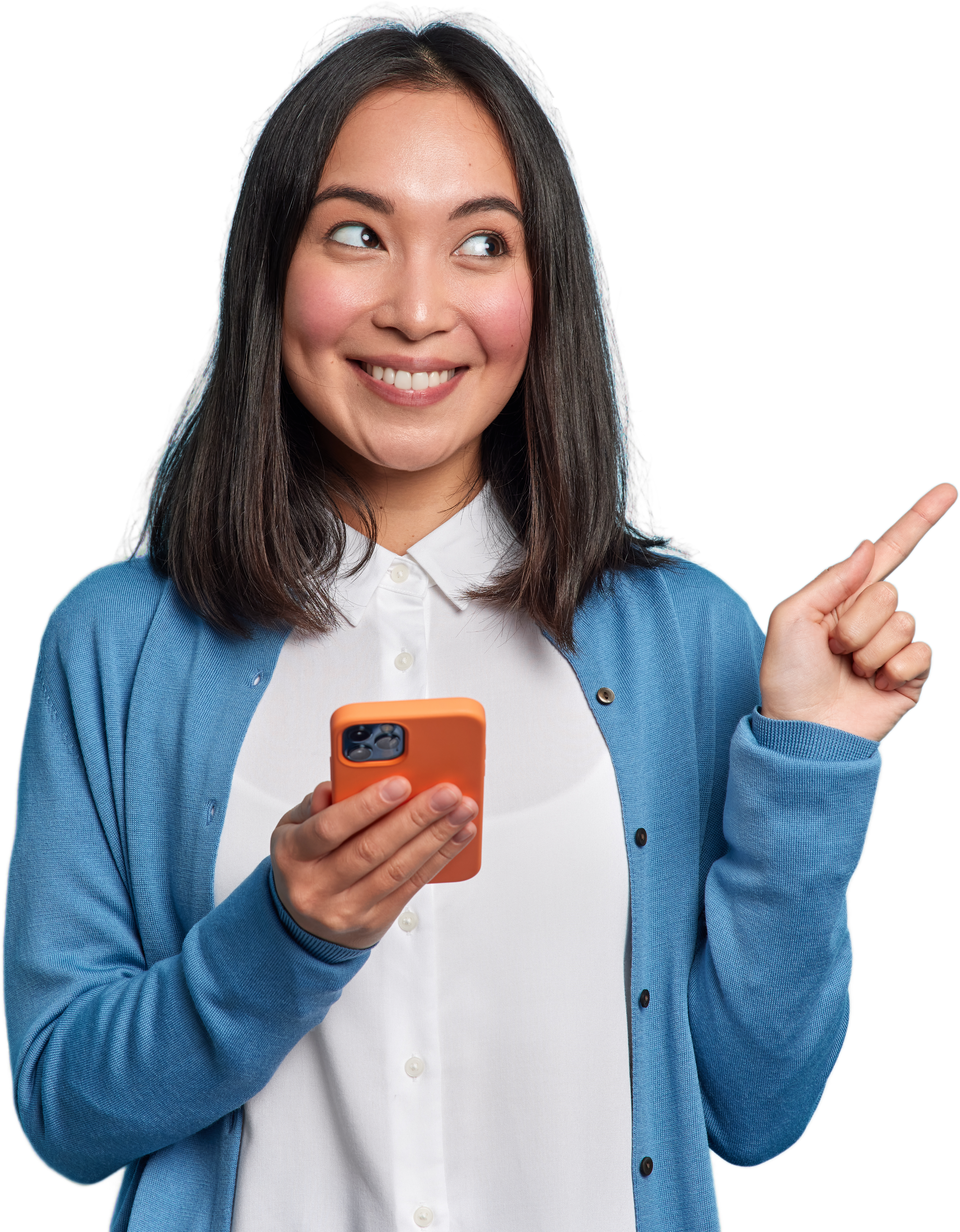 Beautiful Asian woman uses smartphone app sends messages in social media chat points away on copy space wears casual jumper isolated over blue background shows copy space for your advertisement
